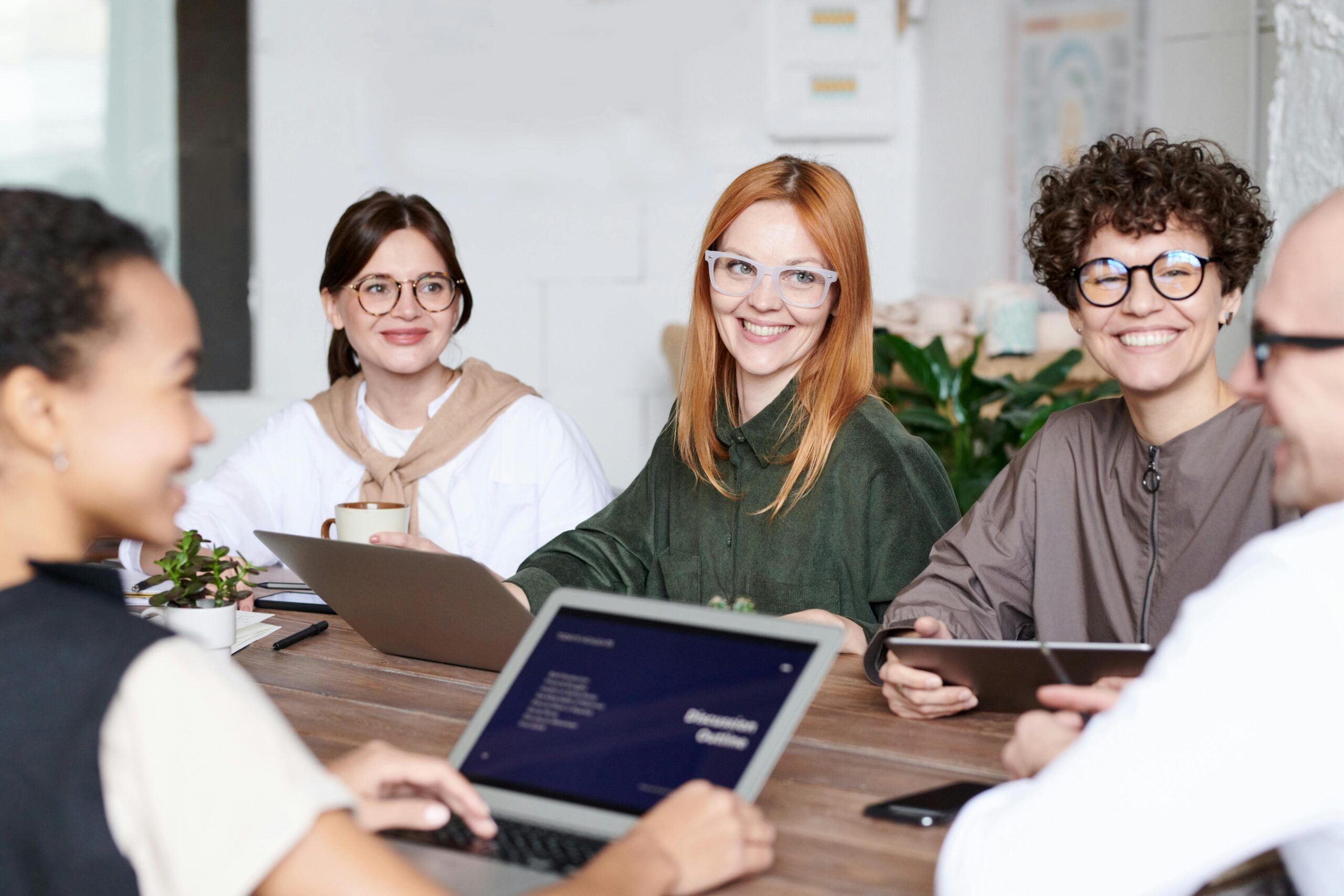 Diverse group of professionals collaborating in an office setting, focusing on teamwork and innovation.